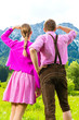 Paar in Tracht auf Wiese vor Bergpanorama