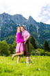 Paar in Tracht auf Wiese vor Bergpanorama