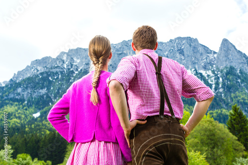 Photo: Paar in Tracht auf Wiese vor Bergpanorama Paar in Tracht auf Wiese vor Bergpanorama