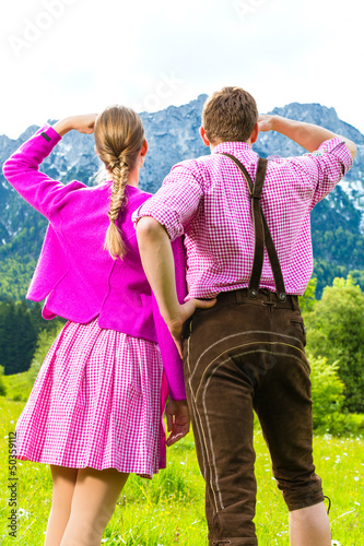 Photo: Paar in Tracht auf Wiese vor Bergpanorama Paar in Tracht auf Wiese vor Bergpanorama