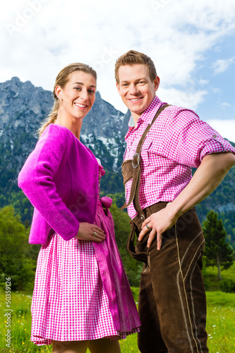Photo: Paar in Tracht auf Wiese vor Bergpanorama Paar in Tracht auf Wiese vor Bergpanorama
