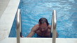Young man getting out of the swimming pool, slow motion shot at 