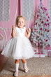The girl at the Christmas fir-tree with gifts