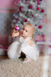 The girl at the Christmas fir-tree with gifts