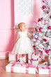 The girl at the Christmas fir-tree with gifts