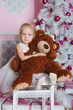 The girl at the Christmas fir-tree with gifts