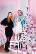 The little girl with ðîäèòåëÿìèó a white Christmas fir-tree