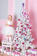 The girl at the Christmas fir-tree with gifts