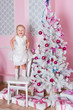 The girl at the Christmas fir-tree with gifts
