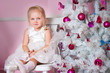 The girl at the Christmas fir-tree with gifts