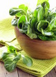 Fresh green salad valerian in a wooden bowl