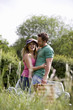 A young couple carrying a picnic basket in summertime
