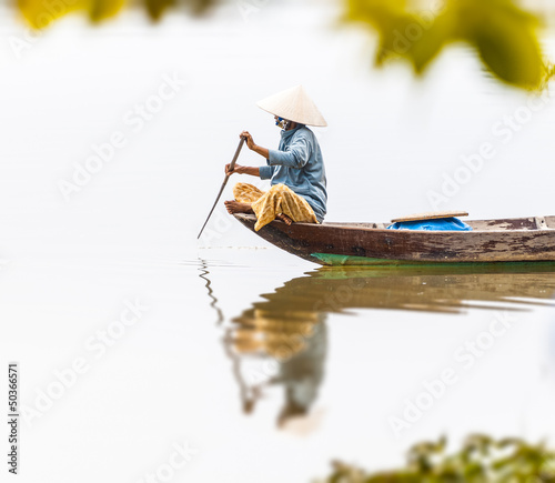 Photo: Woman on wooden boat in river in Vietnam, Asia. Woman on wooden boat in river in Vietnam, Asia.
