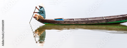 Photo: Woman on wooden boat in river in Vietnam, Asia. Woman on wooden boat in river in Vietnam, Asia.