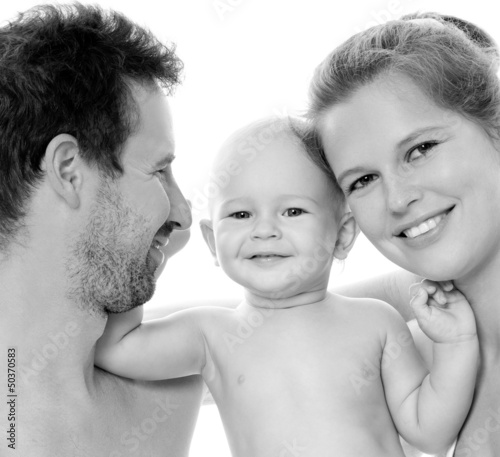 Photo: Happy young family with baby. Indoors. Happy young family with baby. Indoors.