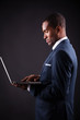 Photo: Business black man whit laptop on black background Business black man whit laptop on black background