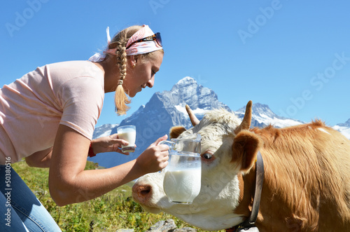 Photo: Girl with a jug of milk and a cow. Jungfrau region, Switzerland Girl with a jug of milk and a cow. Jungfrau region, Switzerland