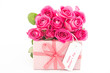Bouquet of pink roses next to a pink gift with a happy mothers d