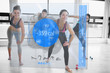 Women doing exercises with trainer while looking futuristic inte