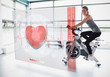 Photo: Young girl doing exercise bike with futuristic interface Young girl doing exercise bike with futuristic interface