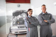Two mechanics standing in front of a futuristic interface