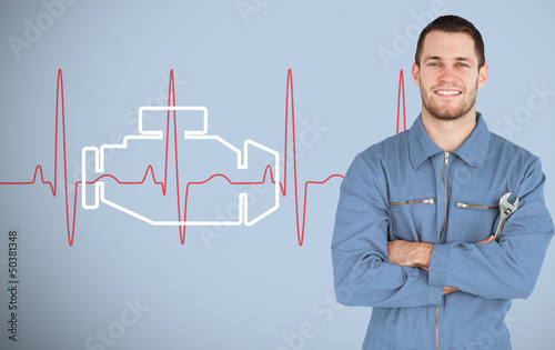 Photo: Portrait of a young mechanic next to background with engine Portrait of a young mechanic next to background with engine