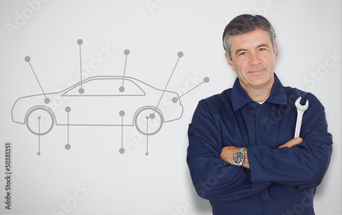 Photo: Mature mechanic standing next to car diagram Mature mechanic standing next to car diagram
