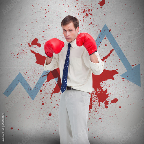 Photo: Businessman in boxing gloves against loss arrow and blood spatte Businessman in boxing gloves against loss arrow and blood spatte