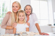 Photo: Cheerful mothers and daughters cooking together Cheerful mothers and daughters cooking together