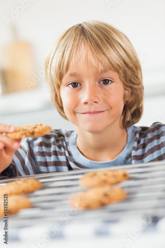 Photo: Smiling boy holding a cookie Smiling boy holding a cookie