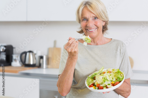 Photo: Smiling woman eating salad Smiling woman eating salad