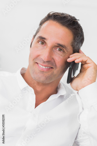 Photo: Man looking happy and talking on the phone Man looking happy and talking on the phone
