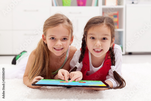 Photo: Little girls using tablet computer as artboard Little girls using tablet computer as artboard