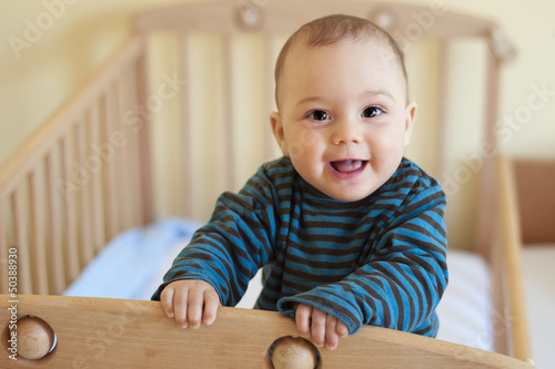 Photo: Baby standing in cot Baby standing in cot