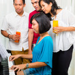 Asian people sitting together at the piano