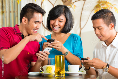 Photo: Asian people having fun with mobile phone Asian people having fun with mobile phone
