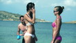 Man makes a joke two women on the beach, slow motion shot at 240