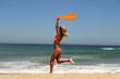 Beautiful tanned woman running on the beach.