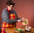 Woman preparing salad  on an orange background