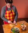 Woman preparing salad  on an orange background