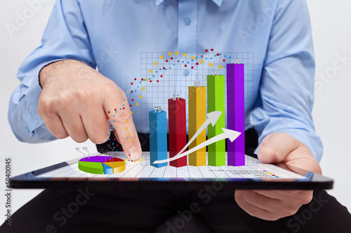 Photo: Businessman working on annual report - closeup on charts Businessman working on annual report - closeup on charts