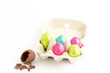Carton of easter eggs with one broken on surface