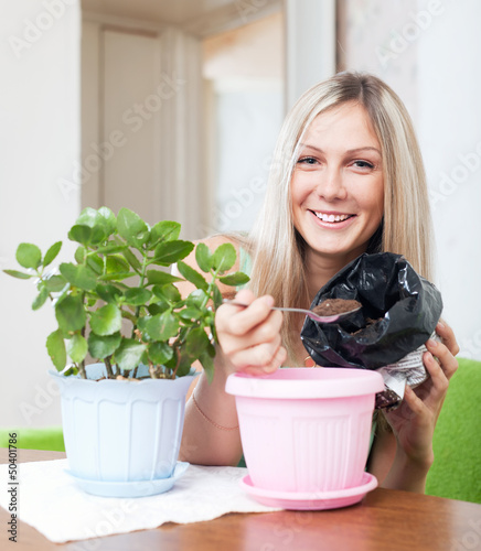 Photo: Smiling woman transplants Kalanchoe plant Smiling woman transplants Kalanchoe plant