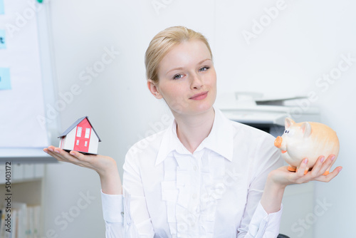 Photo: maklerin mit haus und sparschwein maklerin mit haus und sparschwein