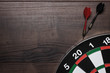 target and two darts over brown wooden table background