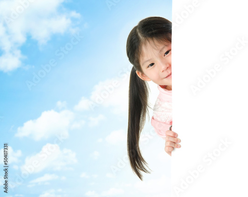 Photo: Asian girl hiding behind a blank white card Asian girl hiding behind a blank white card