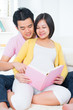 Foto: Asian pregnant couple reading book Asian pregnant couple reading book