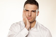 a young man with a toothache on white background
