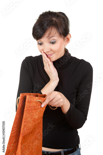 Photo: young woman with curiosity looking to present bag young woman with curiosity looking to present bag