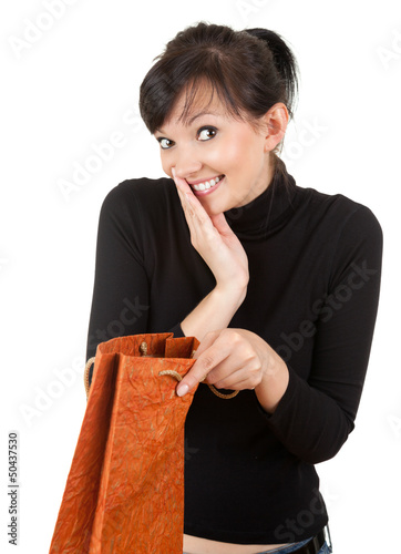Photo: surprised young woman with gift bag surprised young woman with gift bag